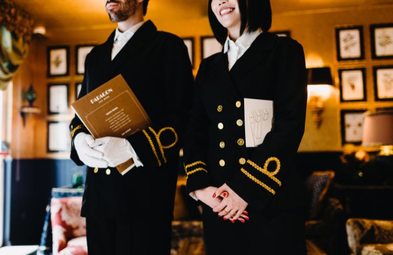 Waiter and Waitress in Black Uniforms with Gold Trim