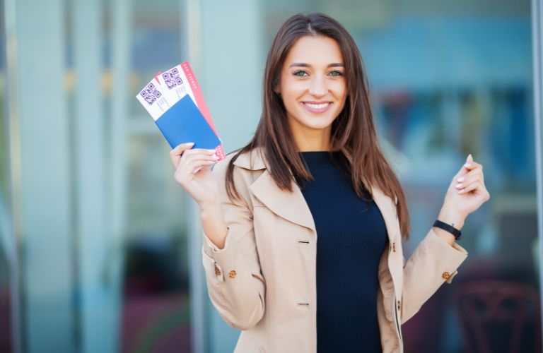 Woman Holding Up Two Plane Tickets