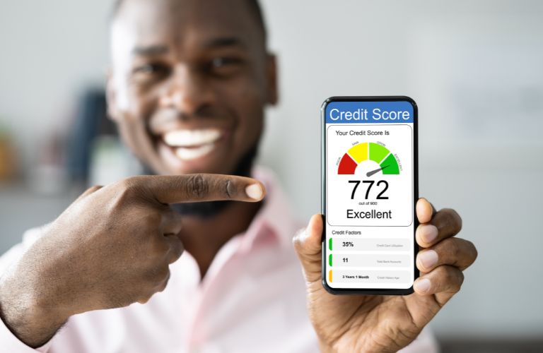 Happy Man Holding Up Phone with a Credit Score