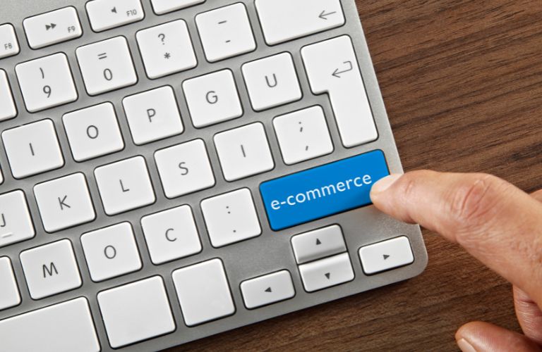 Person Pressing E-Commerce Button on Laptop
