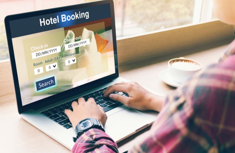 Man Using a Laptop to Book a Hotel