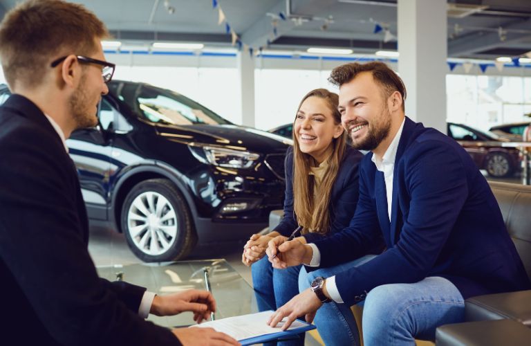 Couple Speaking with a Car Dealer in a Dealership