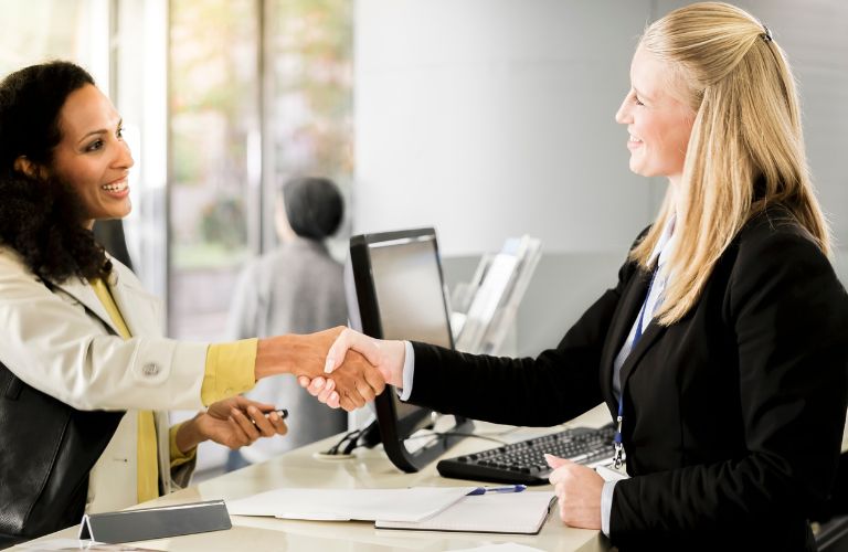Woman Shaking Hands with Female Bank Teller