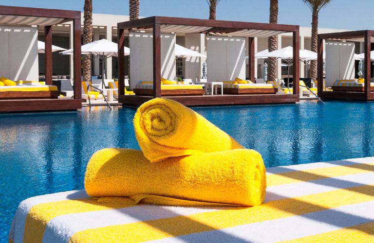 Yellow Towels on a Pool Chair by a Pool