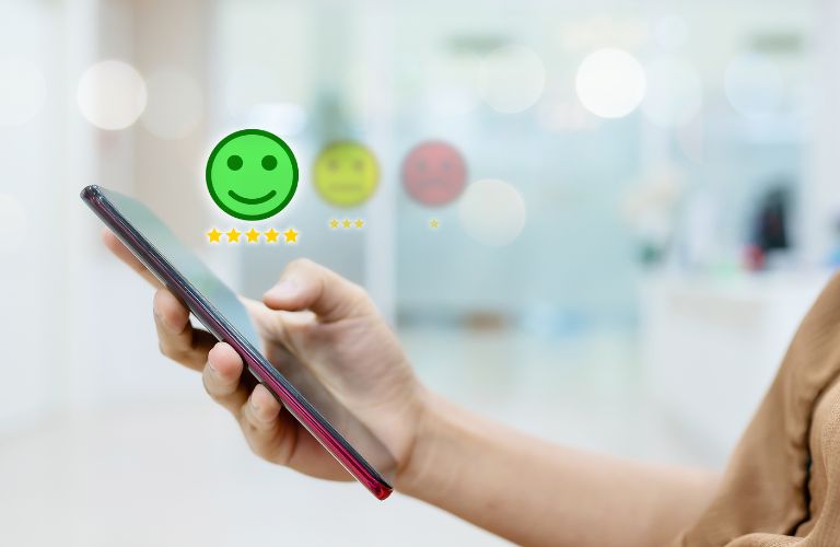 Person Using Smartphone with Green Smiley Face Above