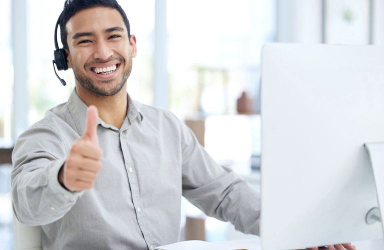 Customer Service Rep at Computer Giving Thumbs Up