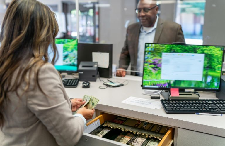 Bank Teller Giving Cash to Customer